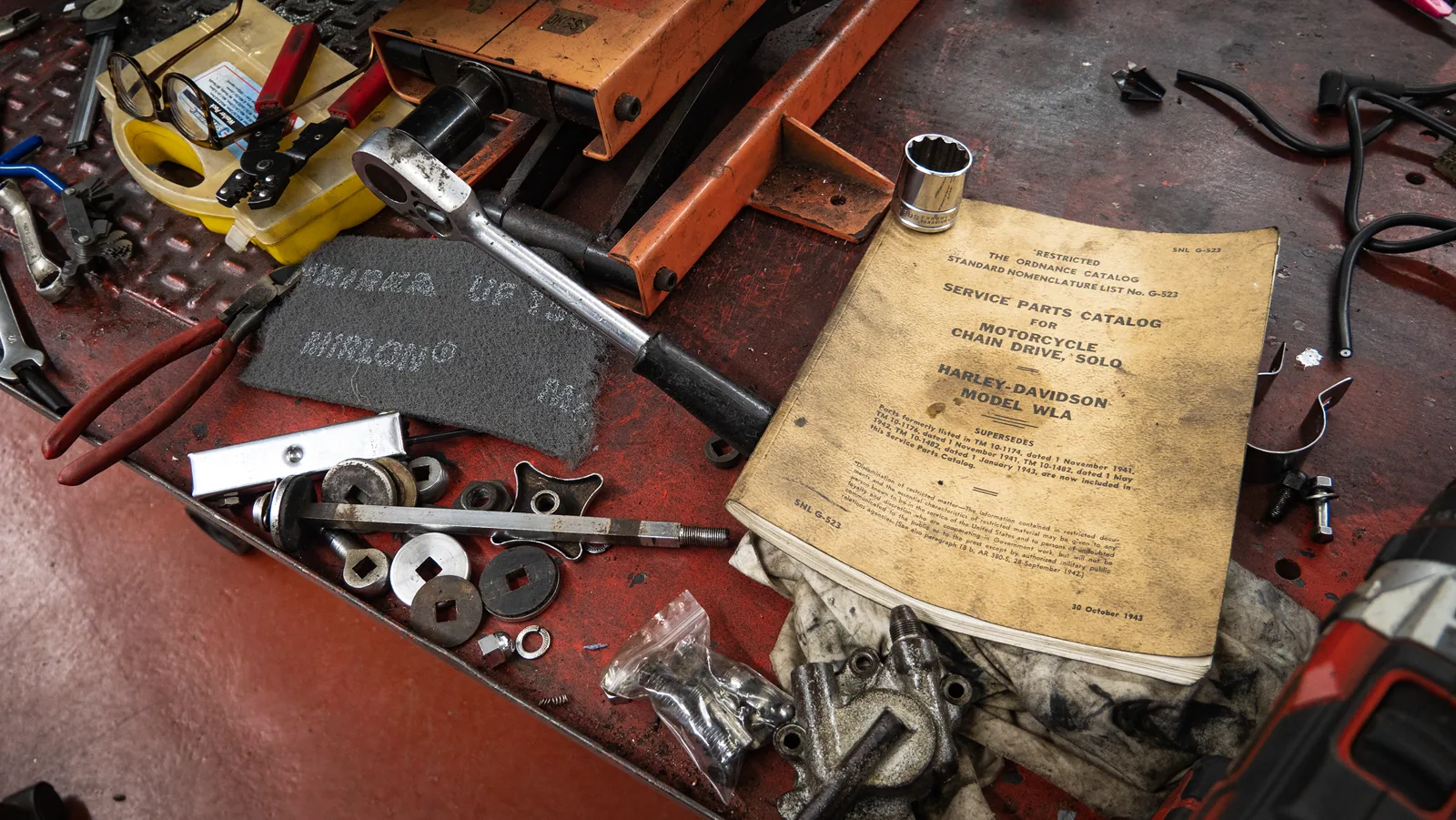 Tools and a service parts catalogue on the workshop bench